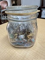 Glass clamp-top jar filled with mixed jewelry
