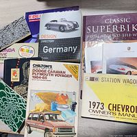Group of manuals and books including Design Directory Germany, Classic Superbikes, Chilton’s Dodge Caravan/Plymouth Voyager manual, 1973 Chevrolet owner’s manual