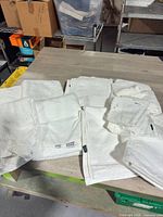 Grouped stacks of assorted white towels on table