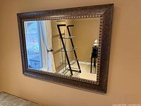 Front view of rectangular wall mirror showing double border frame and reflection