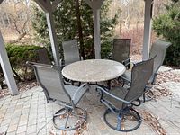 Granite patio dining set under gazebo showing table and six chairs