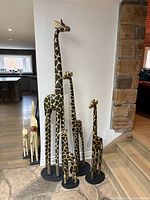 All four black-and-tan giraffe sculptures grouped, heights visible