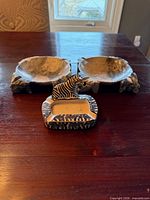 All three ashtrays: Besmo zebra ashtray front, two round stone ashtrays behind