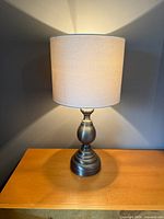 Full view of first lamp illuminated showing shade and base