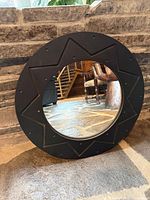Front view of black starburst round mirror