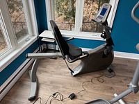 Left side view of Vision Fitness R2100 recumbent bike showing frame, seat, console, and power cord