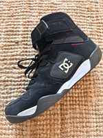 Left shoe side view showing DC logo, strap, outsole