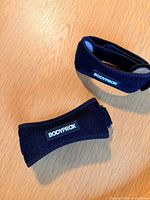 Two Bodyprox knee straps on tabletop, logo visible