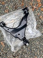 Overall view of new front lower control arm on packaging