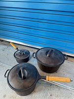 Group shot of Dutch oven and two saucepans with lids