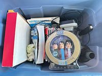 Top view of bin showing books, Yoda figure, Elvis PEZ set and other items