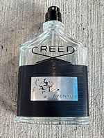 Creed Aventus perfume bottle front view showing design, label, spray top and fill level