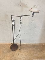 Full view of bronze swing-arm floor lamp with cord