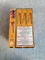 Side view showing three included VHS titles and bonus offer text