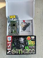 Open retail box showing MSI G4Ti4200 graphics card in anti-static bag with included adapter and cable