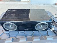 Front view of Samsung speaker showing two driver grilles and brand logo