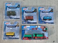 Group shot of five sealed Thomas & Friends train items