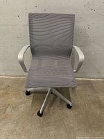 Front view of gray mesh Uline office chair with white frame and casters