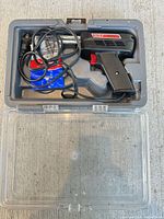 Kit open showing soldering gun, cord, case and spare tips