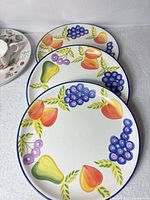 Three large fruit pattern dinner plates