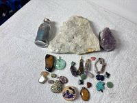 Group shot showing quartz cluster, amethyst cluster, vial and array of stones and pendants