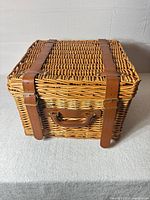 closed wicker basket showing exterior condition and leather straps