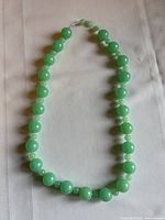 Full view of green bead necklace laid flat