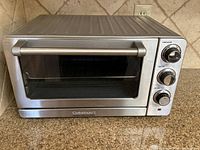 Front view of stainless steel Cuisinart convection toaster oven broiler showing glass door and control dials
