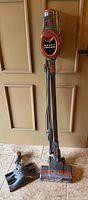 Full view of Shark Rocket stick vacuum standing upright with cord wrapped