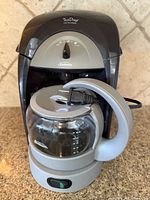 Front view of Sunbeam TeaDrop hot tea maker showing carafe, power cord, control switch and branding