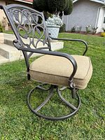 Full view of swivel rocker chair showing metal frame, cushion, base