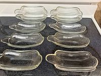 Top view showing all ten clear glass dishes arranged on stovetop