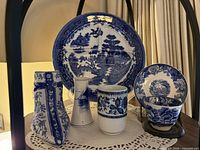 Front view of plate, vases, cup, saucer on shelf