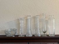Group shot of five vases and one bowl on shelf