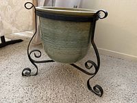 planter in stand, side view showing glaze and scroll legs
