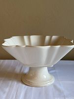 Side profile showing square fluted body on pedestal base