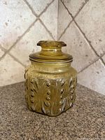 Front view of amber Federal Glass Show Off jar with lid