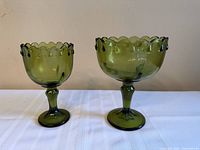 Front view of both olive green Indiana Glass pedestal compote goblets