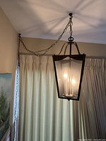Lantern hanging from ceiling with chain showcased