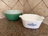 Overall view of both items: green Pyrex bowl left, white Corning Ware casserole right