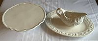 Gravy boat on underplate beside pedestal cake stand