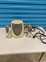 Full view of subwoofer, two satellites, attached cables