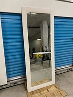 Front view of entire mirror leaning against storage unit