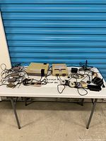 Overall lot on table: both consoles, controllers, cables