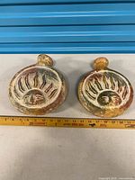 pair of round clay flasks front view with ruler for scale