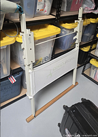 Full view of Booty Kicker barre stand showing frame, wood bar, logo panel, adjustable slots