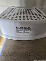 Front view of Dreambaby white plastic step stool showing non-slip top and brand label