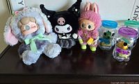 Group shot of two plush toys, vinyl bunny figure and three Tokidoki bear jars