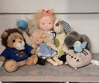 Group shot of all eight plush toys and dolls