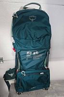 Full view of teal Osprey Poco LT child carrier backpack standing upright
